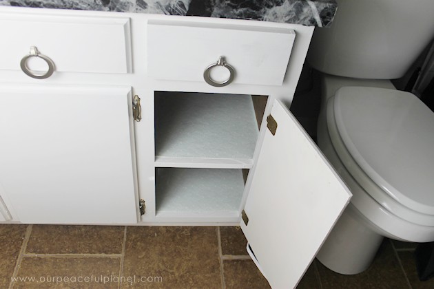 Learn how to make an inexpensive pull out cabinet organizer using a cardboard box so you can easily access things in the far reaches of your lower cabinets.