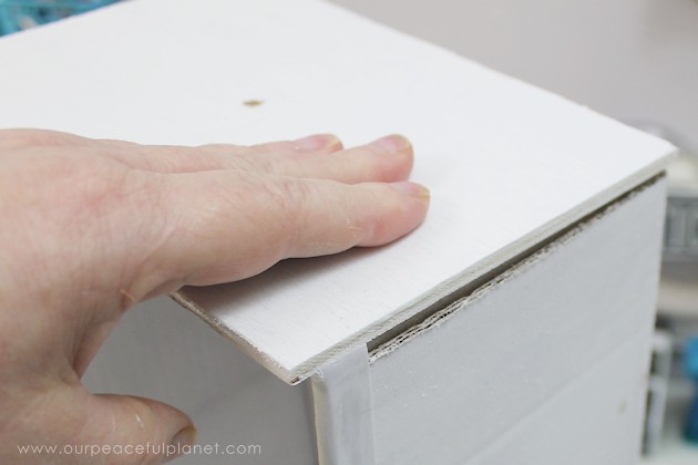 Learn how to make an inexpensive pull out cabinet organizer using a cardboard box so you can easily access things in the far reaches of your lower cabinets.