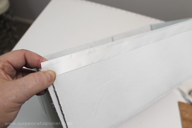 Learn how to make an inexpensive pull out cabinet organizer using a cardboard box so you can easily access things in the far reaches of your lower cabinets.