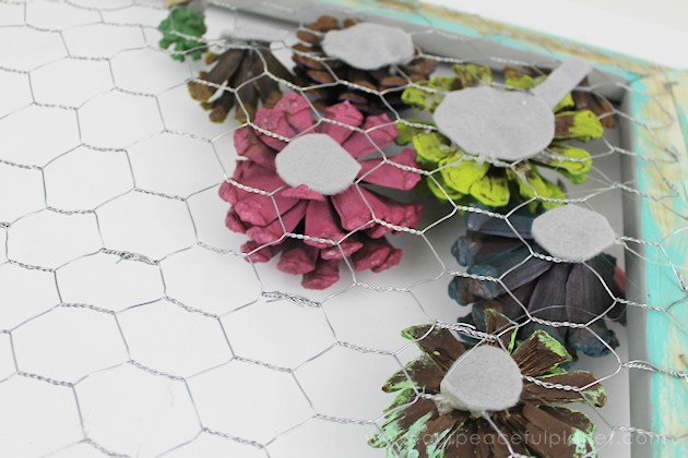 A country chicken wire frame memo board that will brighten up your kitchen with its pretty pinecone succulents. It holds useful items plus photos & quotes!