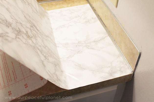 Transform your bathroom for only a few dollars with a contact paper countertop. You'll be amazed at how beautiful it looks & so will your family & guests!
