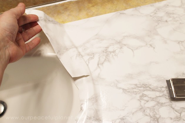 Transform your bathroom for only a few dollars with a contact paper countertop. You'll be amazed at how beautiful it looks & so will your family & guests!
