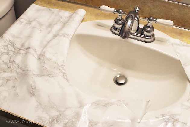 Transform your bathroom for only a few dollars with a contact paper countertop. You'll be amazed at how beautiful it looks & so will your family & guests!