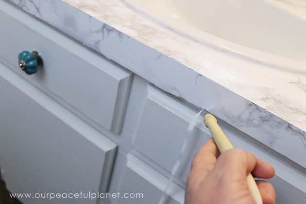 Transform your bathroom for only a few dollars with a contact paper countertop. You'll be amazed at how beautiful it looks & so will your family & guests!