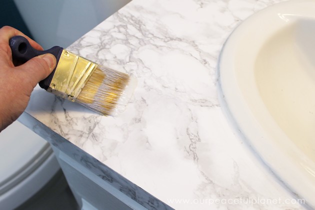 Transform your bathroom for only a few dollars with a contact paper countertop. You'll be amazed at how beautiful it looks & so will your family & guests!
