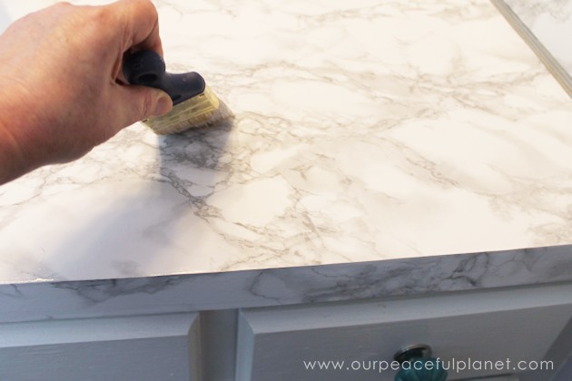 Transform your bathroom for only a few dollars with a contact paper countertop. You'll be amazed at how beautiful it looks & so will your family & guests!
