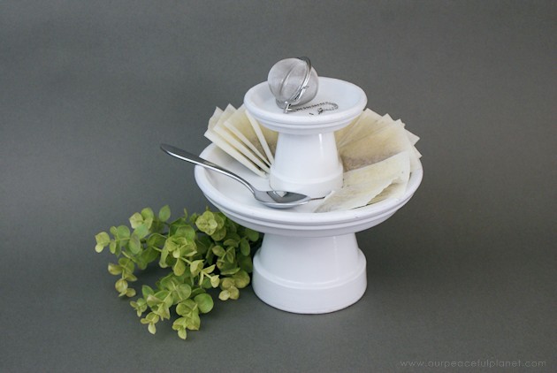 This small DIY cake stand can hold so much more! Fruit, cookies, nuts, candy, tea bags etc. Made from clay pots it’s simple and inexpensive to make. 