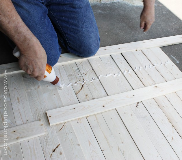 Add some whimsy to your home with this easy DIY picket fence fireplace cover. Made with wood slats and some hinges you can decorate it for any season. 