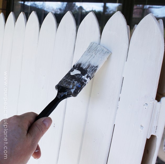 Add some whimsy to your home with this easy DIY picket fence fireplace cover. Made with wood slats and some hinges you can decorate it for any season. 