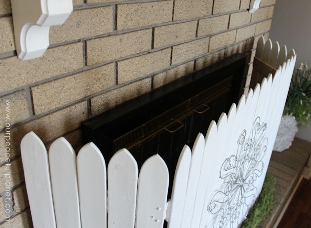 Add some whimsy to your home with this easy DIY picket fence fireplace cover. Made with wood slats and some hinges you can decorate it for any season. 