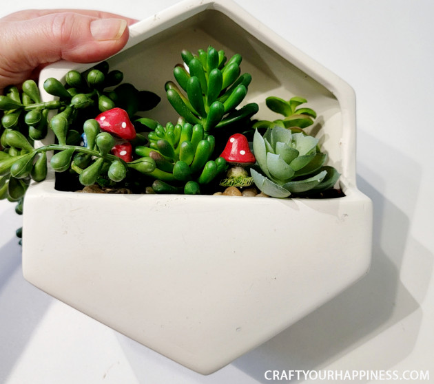 Get Inspired and check out this small hanging planter we turned into a whimsical fairy garden!