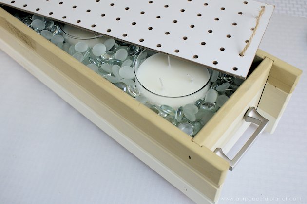 This DIY table centerpiece allows you to change decor year round for any occasion. Then lift out the pegboard insert to find candles for ambient lighting!