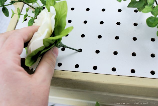 This DIY table centerpiece allows you to change decor year round for any occasion. Then lift out the pegboard insert to find candles for ambient lighting!