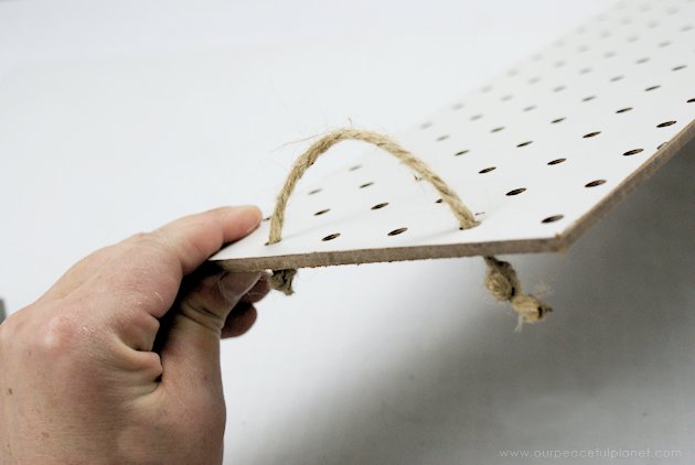 This DIY table centerpiece allows you to change decor year round for any occasion. Then lift out the pegboard insert to find candles for ambient lighting!