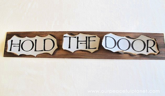 This simple medieval "Hold the Door" sign is part of our Over the Door Decor series. Easy plaques you create to send you out the door with a smile. 