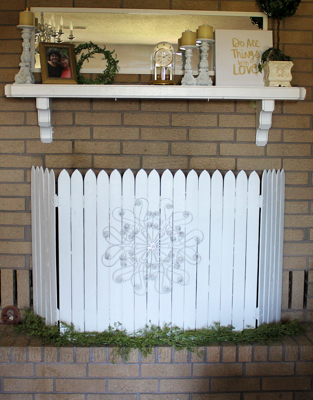 Add some whimsy to your home with this easy DIY picket fence fireplace cover. Made with wood slats and some hinges you can decorate it for any season. 