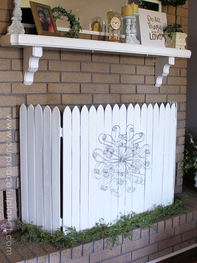 Add some whimsy to your home with this easy DIY picket fence fireplace cover. Made with wood slats and some hinges you can decorate it for any season. 